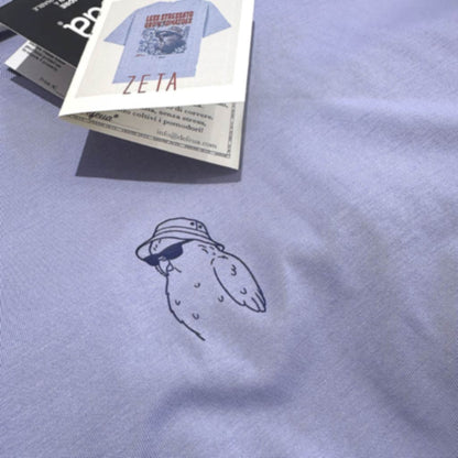 Dettaglio grafica frontale t-shirt Defeua® LESS STRESS con illustrazione kakapo e carta di identità